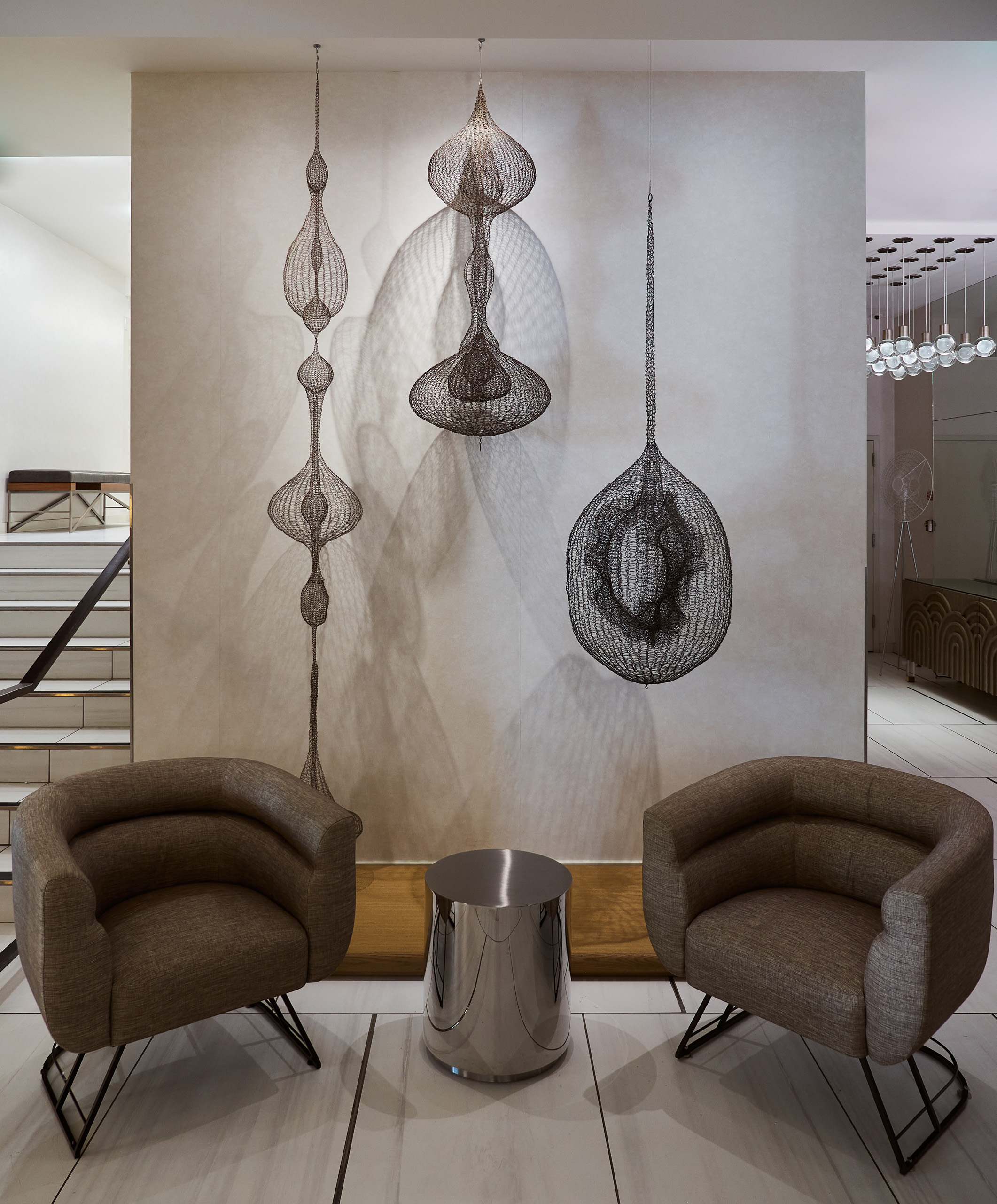 Wire sculptures with two chairs and small table.