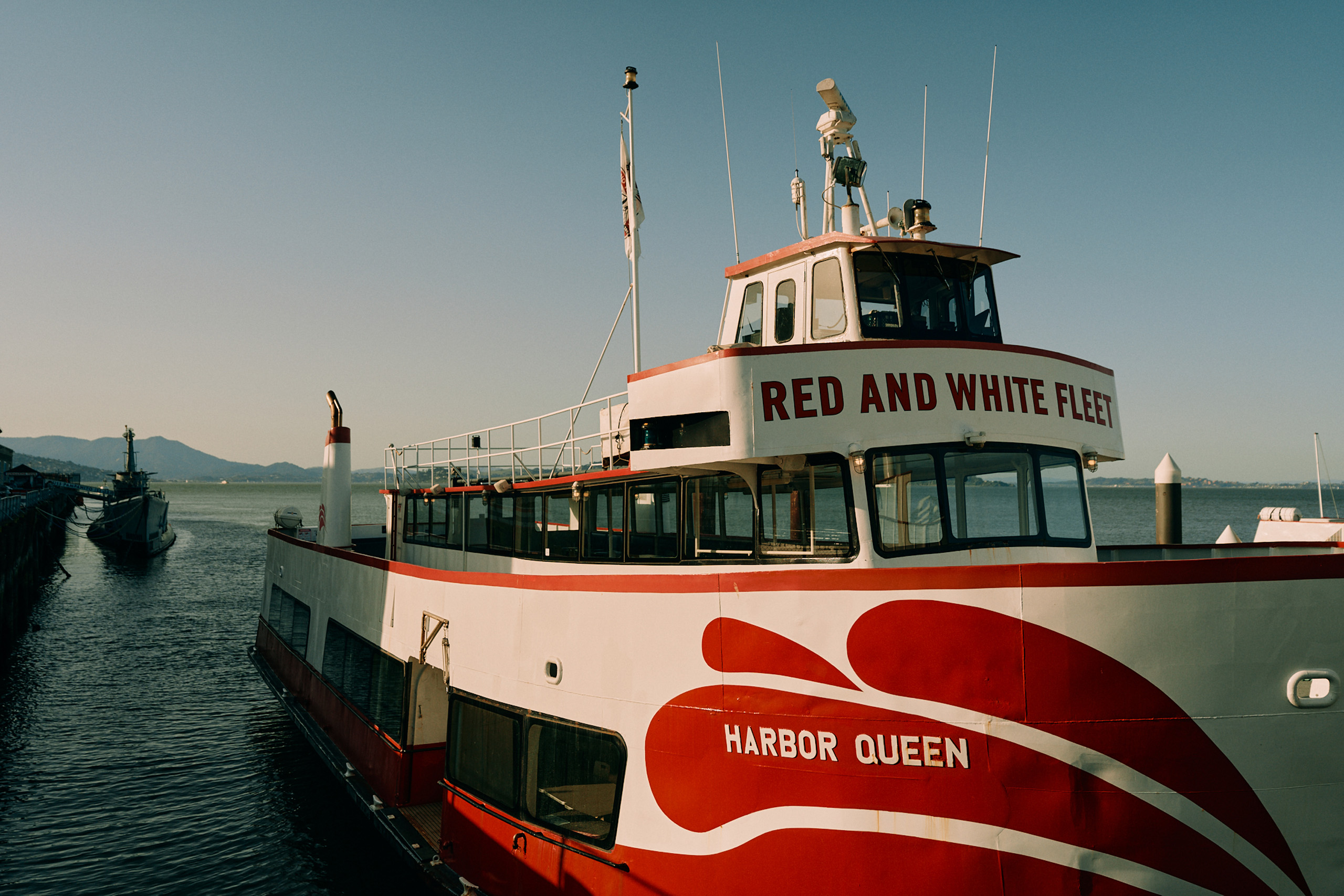 Red and White Fleet tour boat at pier.