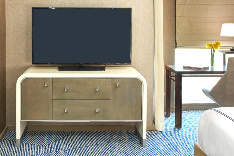 Dresser with TV beside window and desk.