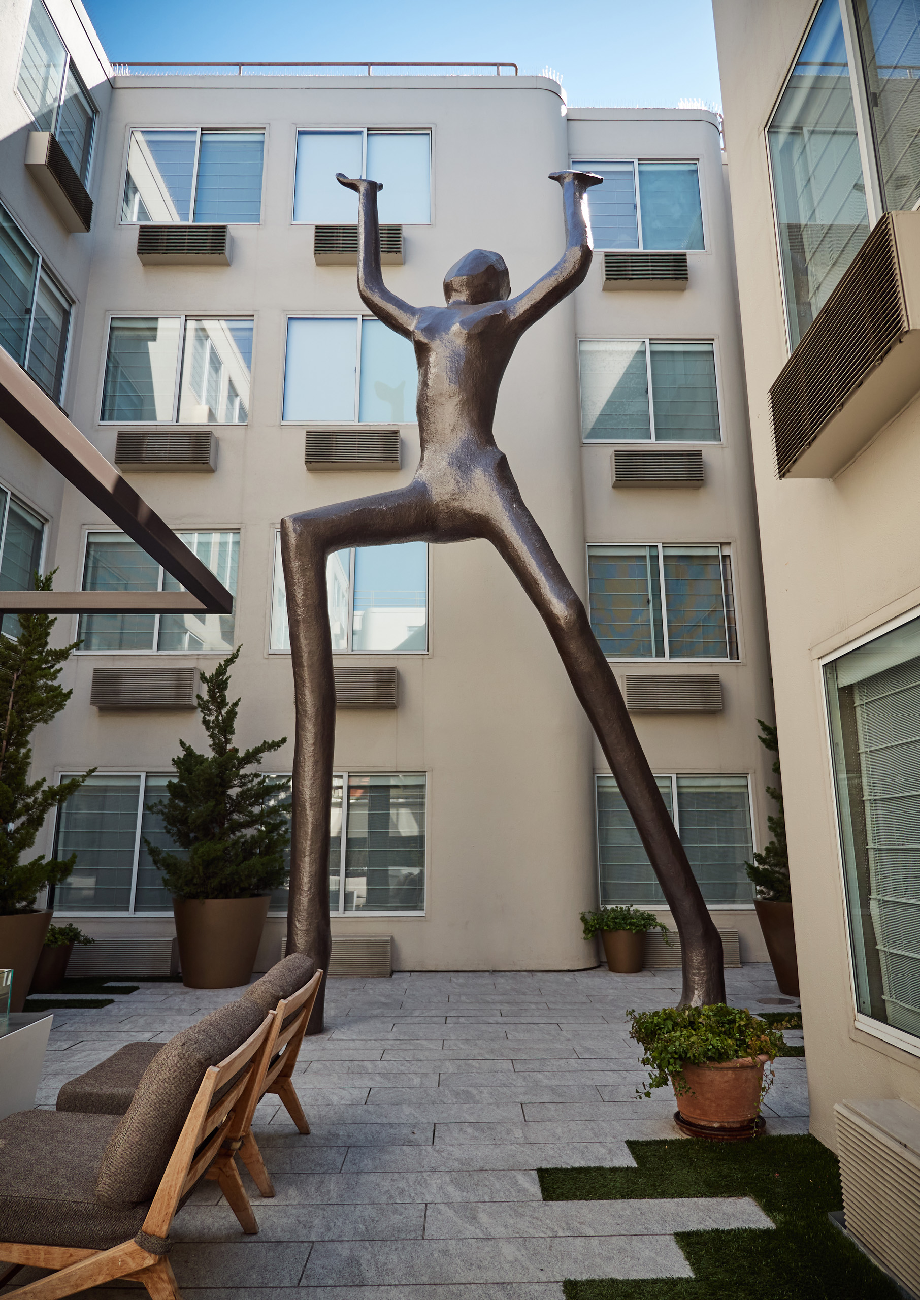Tall abstract bronze statue in hotel courtyard