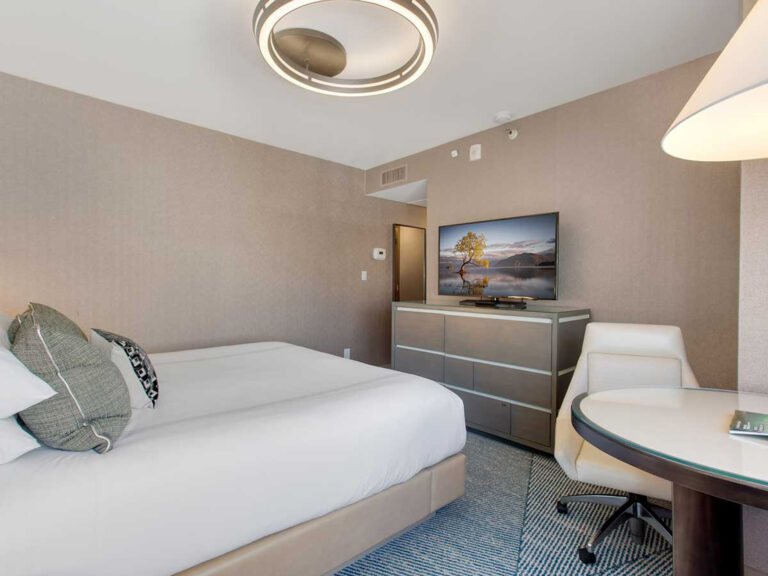 Hotel room with bed, TV, and desk chair