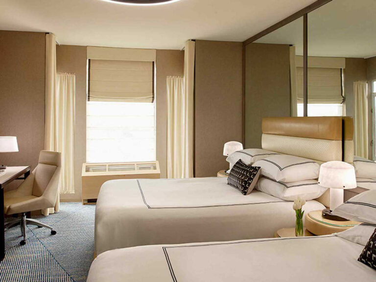 Hotel room with two queen beds and desk.