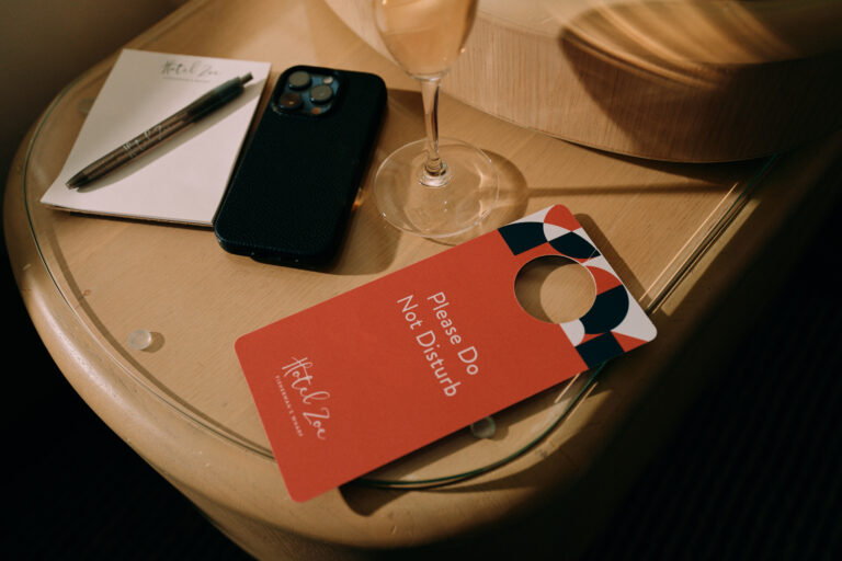 Do-not-disturb tag on nightstand with phone.