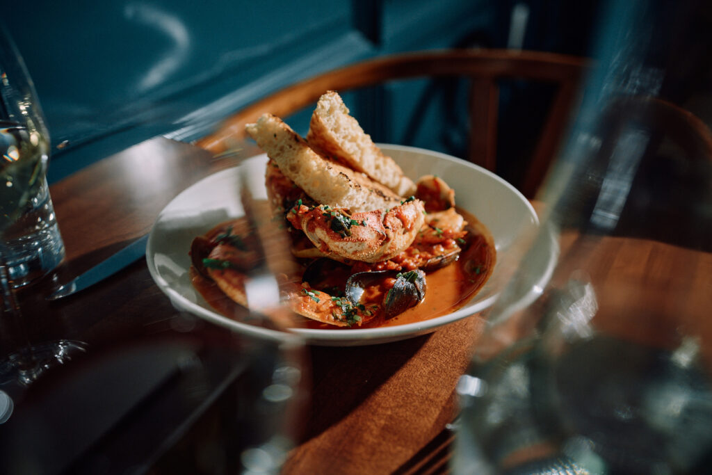 Seafood stew with crab and toast on restaurant table