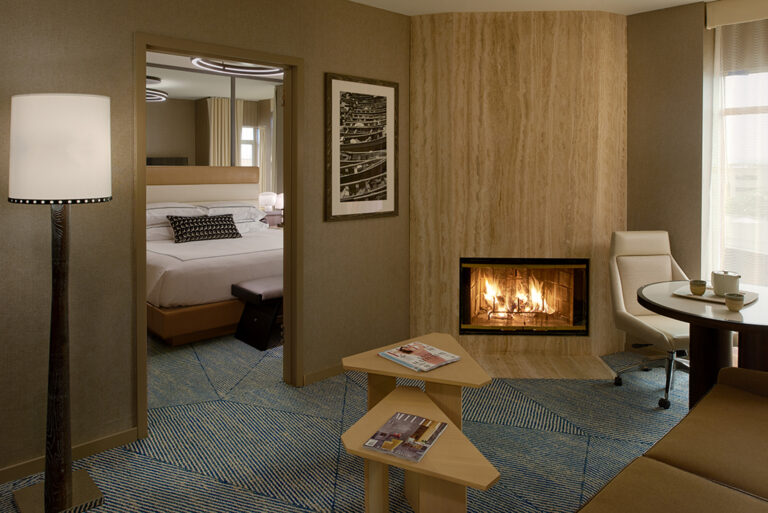 Suite fireplace with seating and bedroom view.