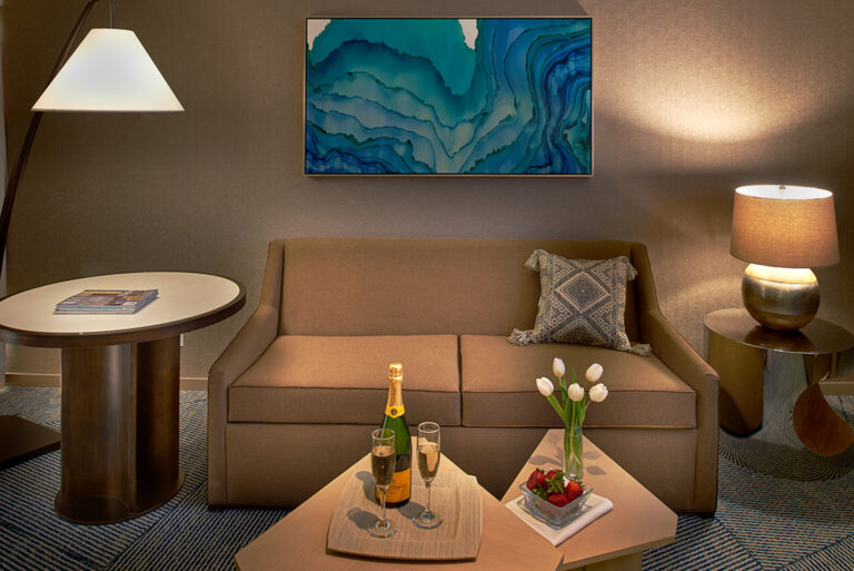 Living room sofa with art and table setup.