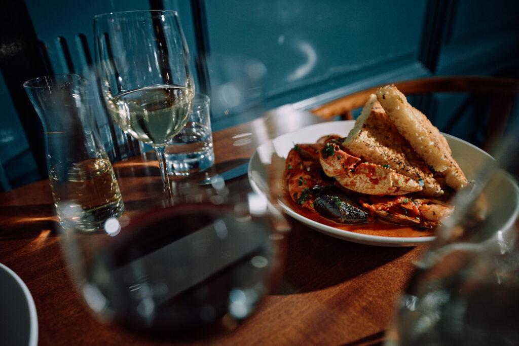 Seafood dish with bread and wine on restaurant table.