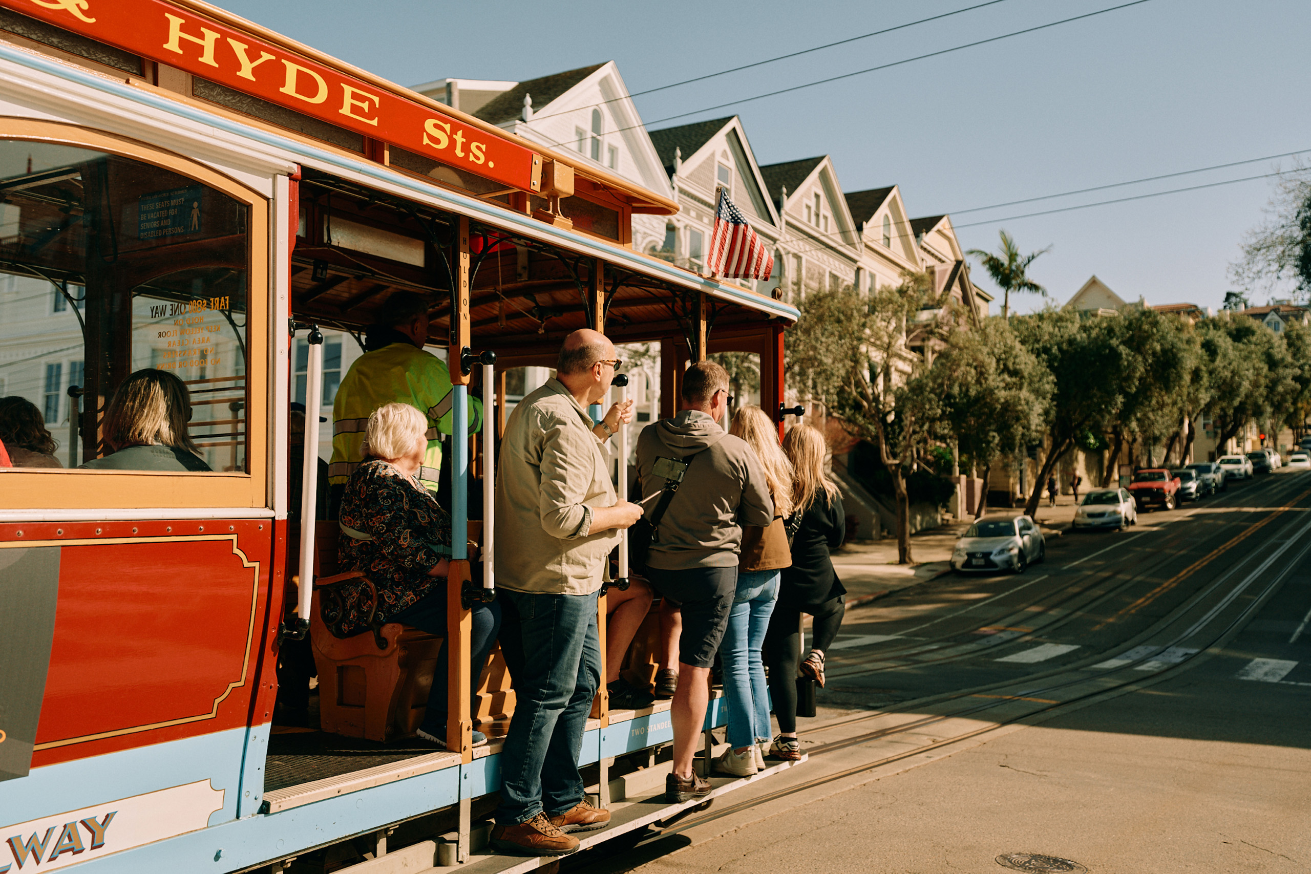 Cable car filled with riders climbing Hyde Street hill.