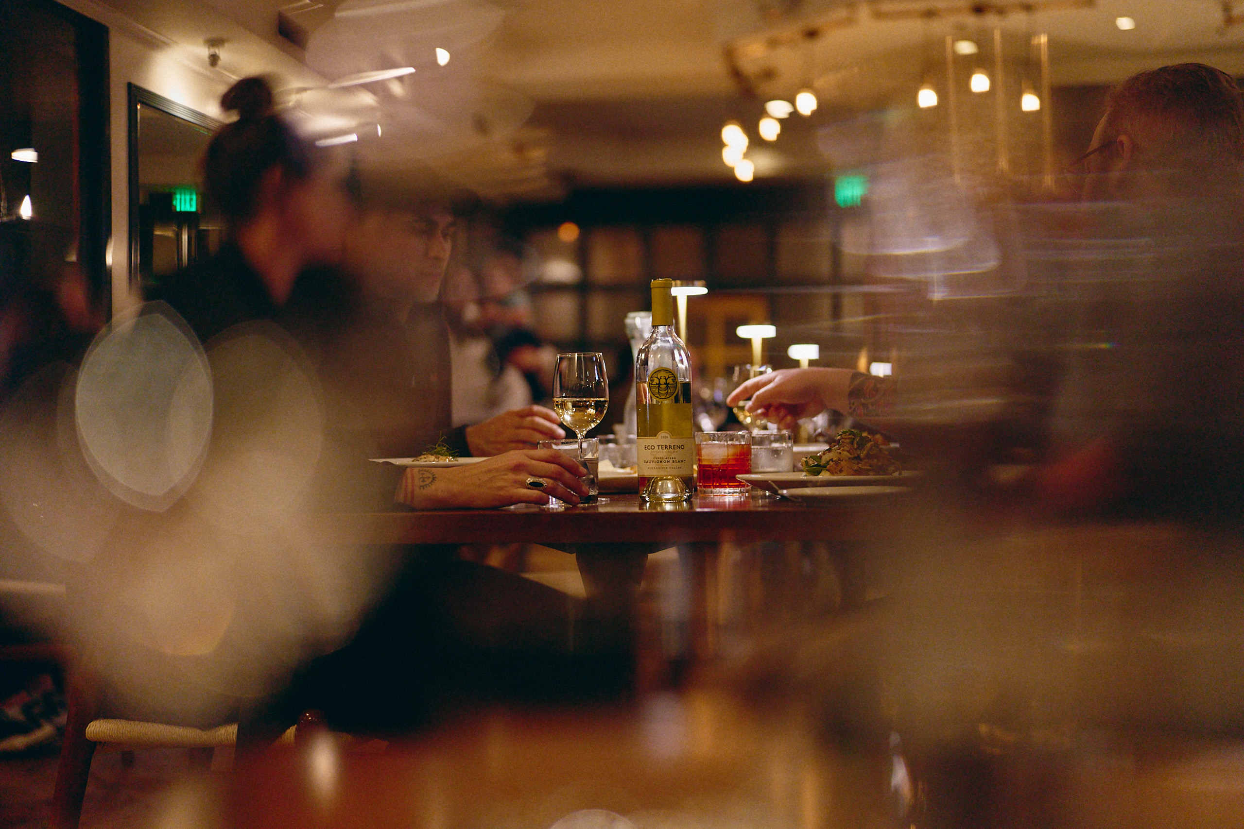 Evening diners enjoying wine at a restaurant table.