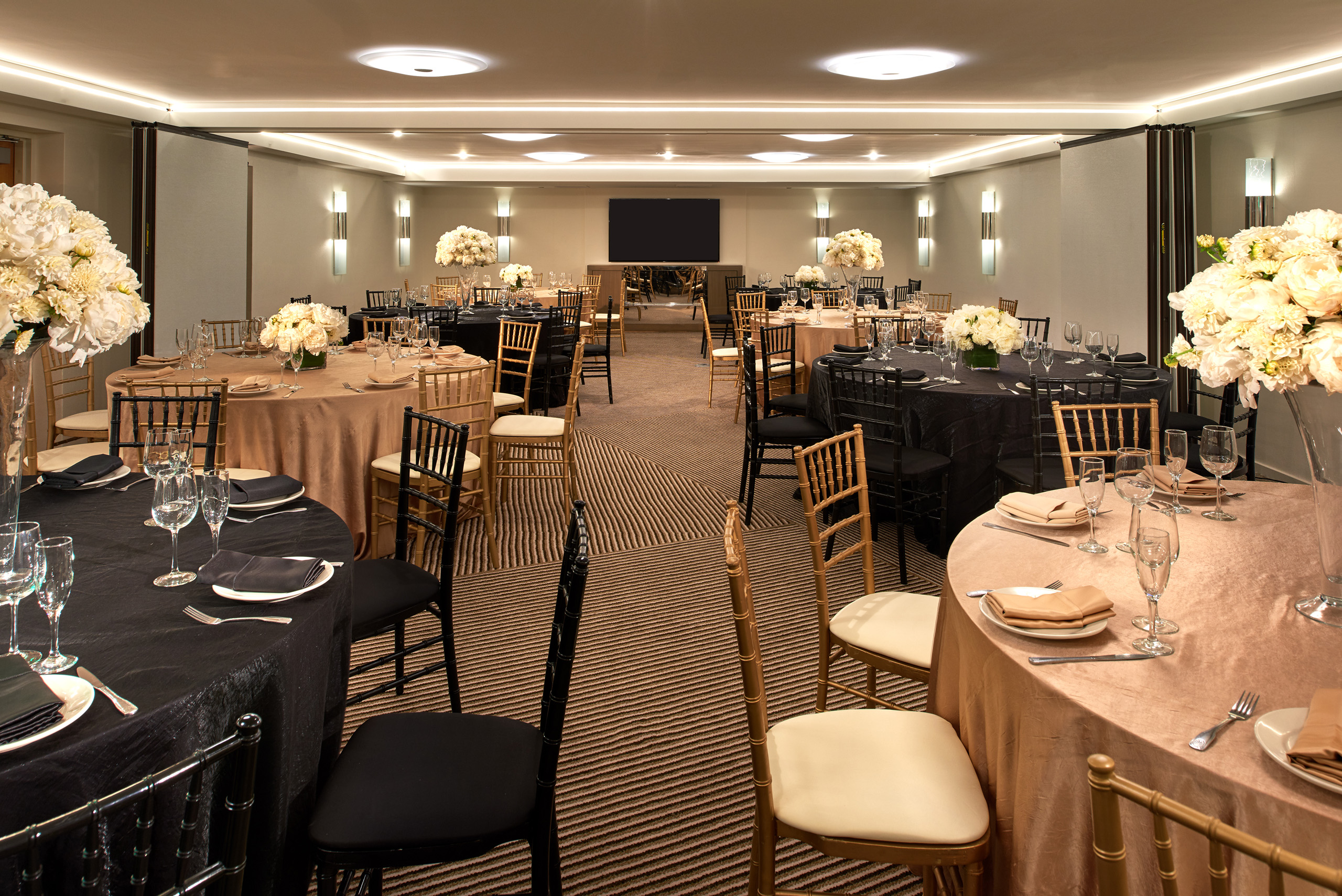 Elegant banquet room with decorated round tables.