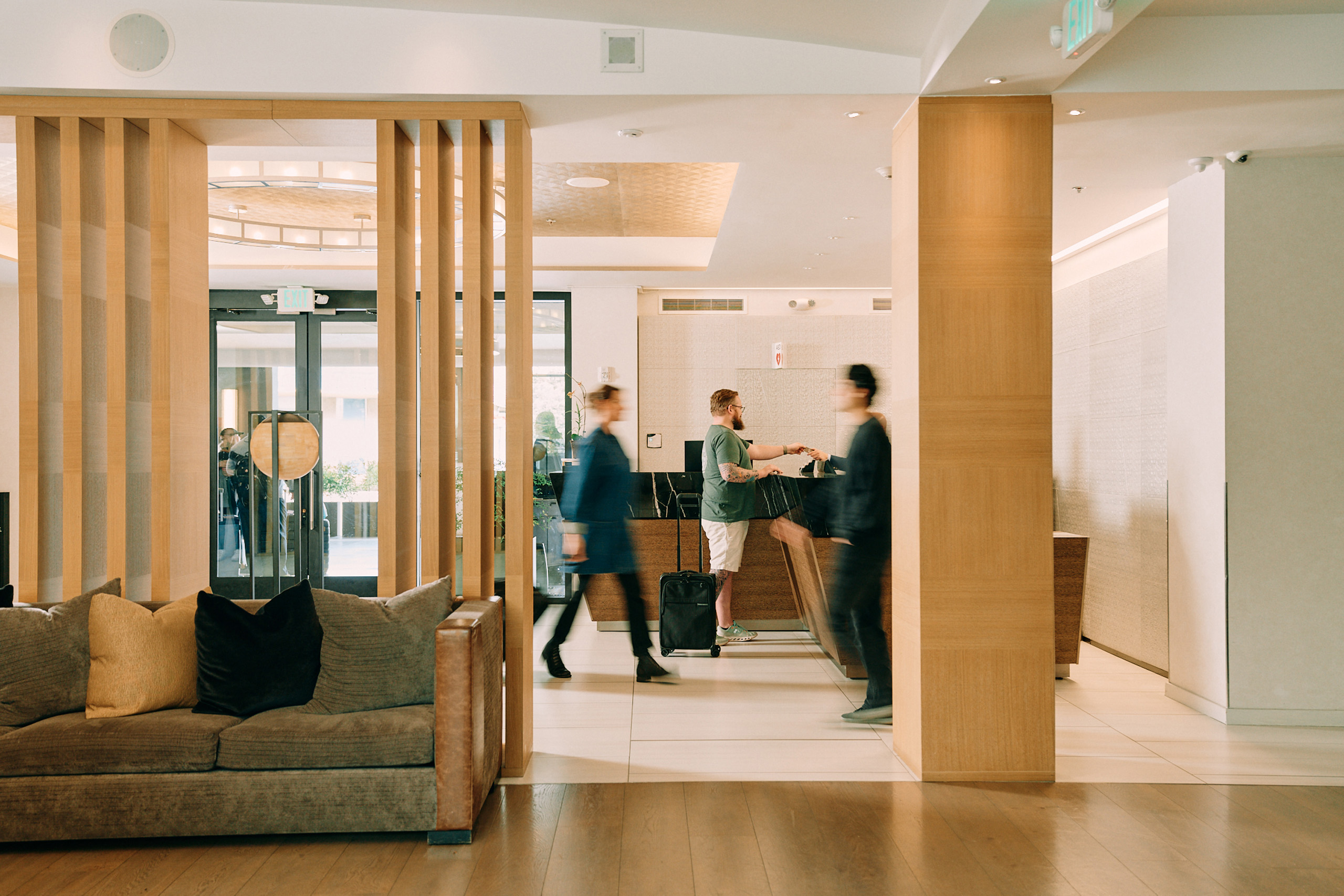 Hotel lobby with guests checking in and staff moving through.