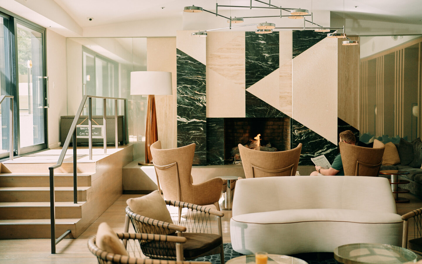 Modern lounge with geometric fireplace and seating.