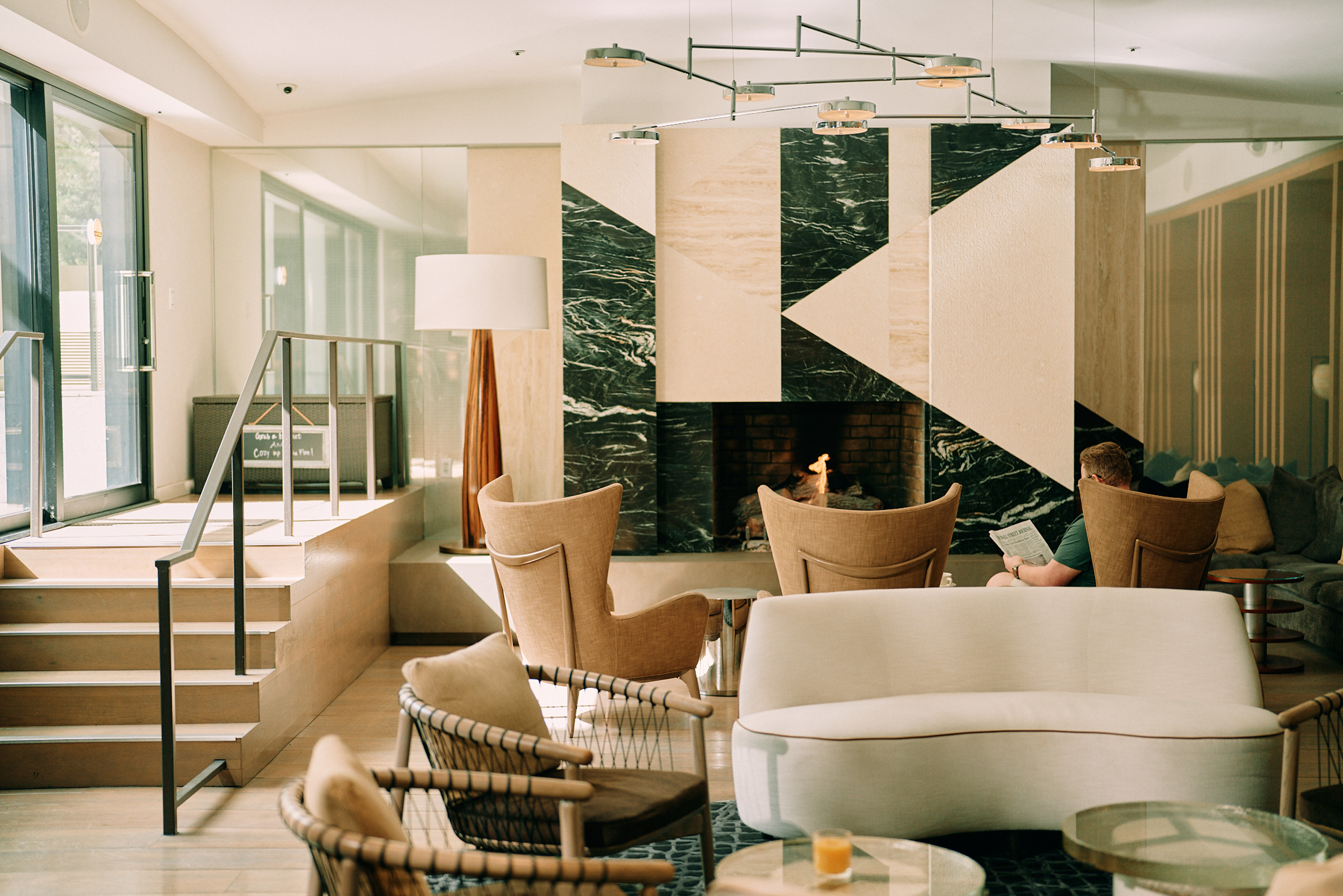 Modern lounge with geometric fireplace and seating.