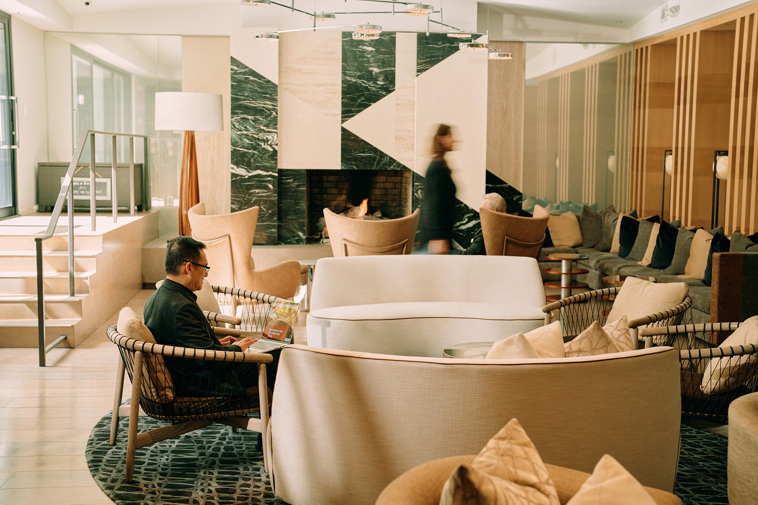 Hotel lobby seating near modern fireplace.