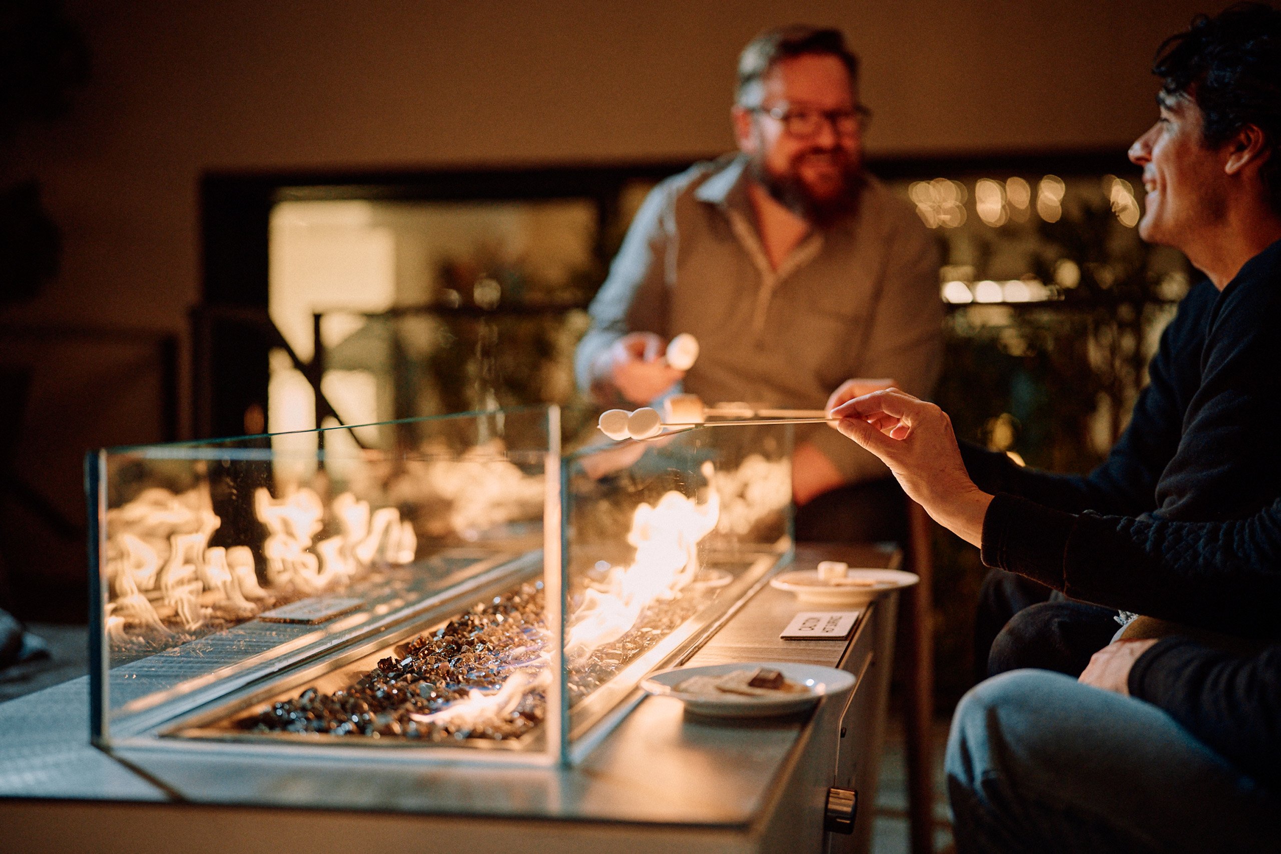 People roasting marshmallows over firepit