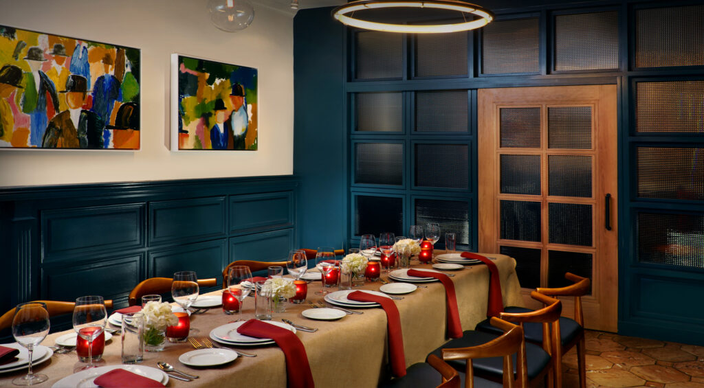 Private dining table set with red napkins and candles.