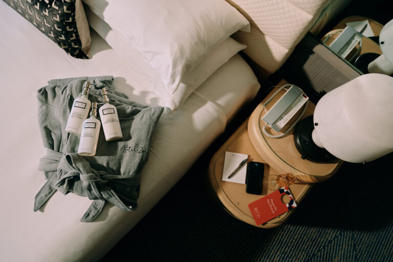 Hotel robe and toiletries arranged neatly on bed.