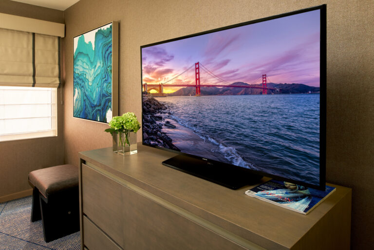 Large flatscreen TV on wooden dresser in suite.