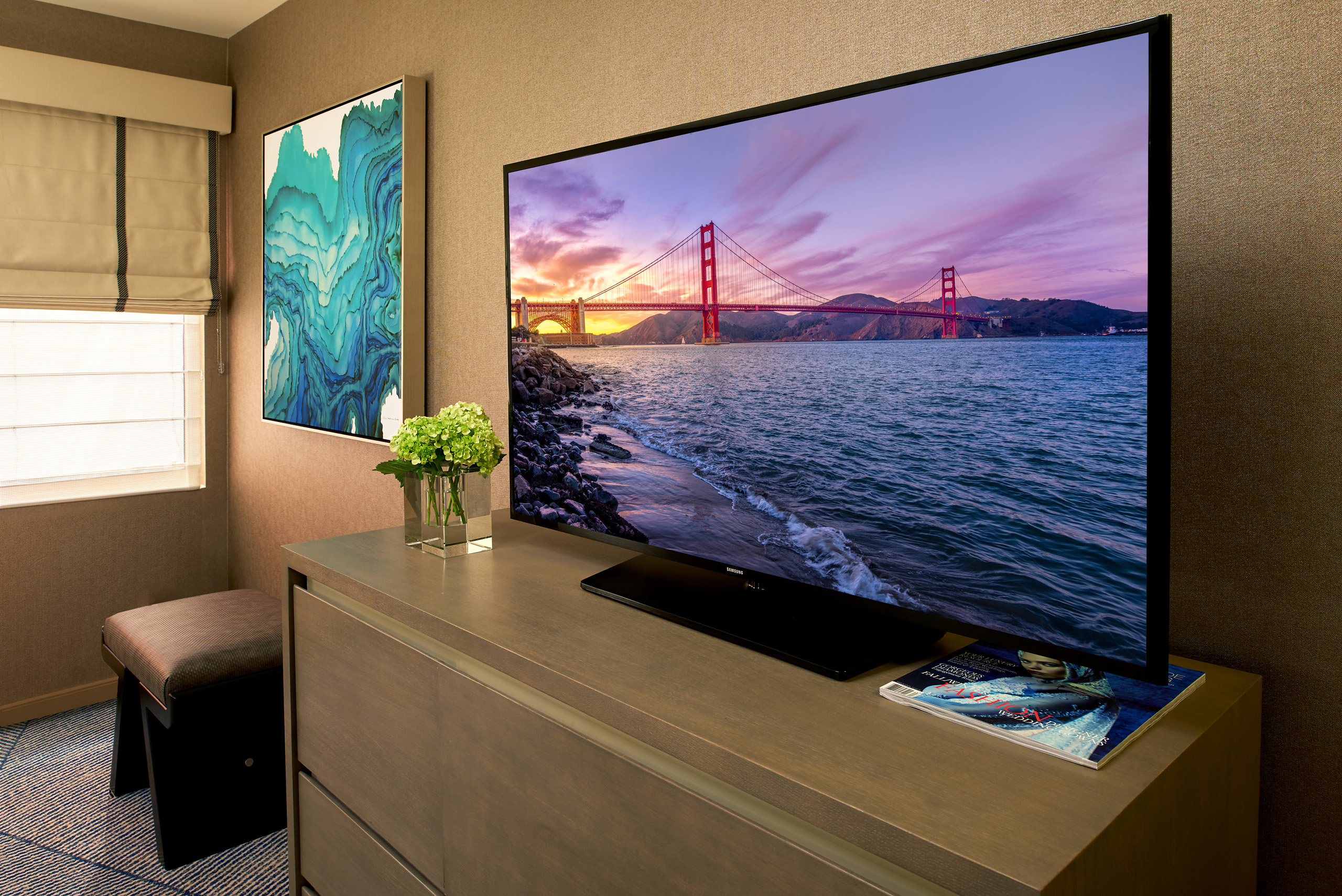 Large flatscreen TV on wooden dresser in suite.