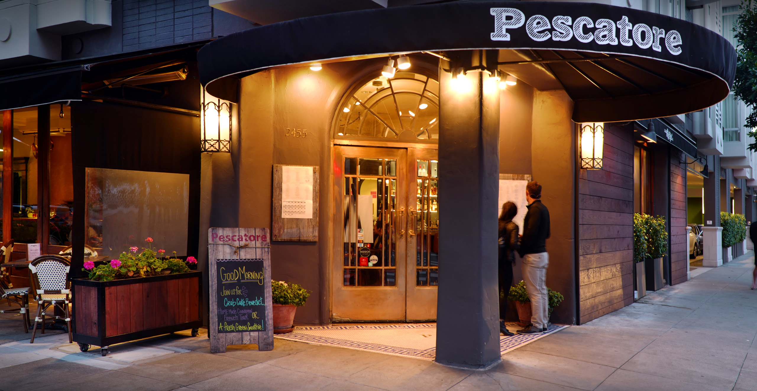 Exterior of Pescatore restaurant warmly lit during the evening.