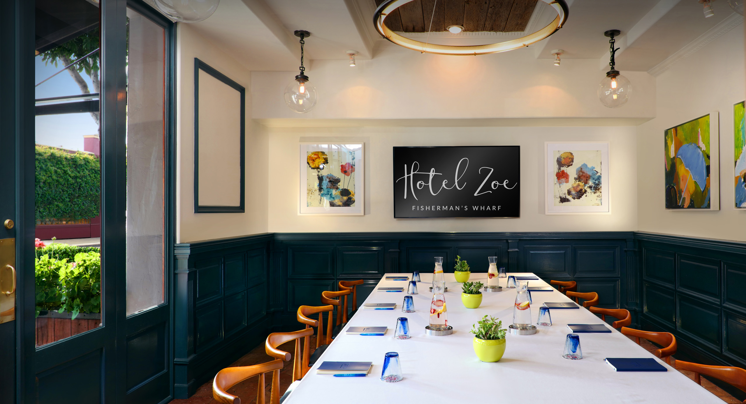 Bright meeting room with long table and colorful artwork.